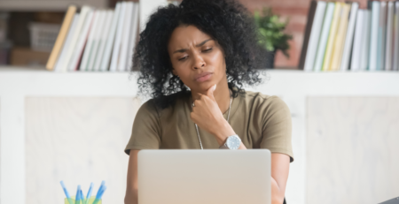 Black women working at a laptop deciding if her webisite is outdated.